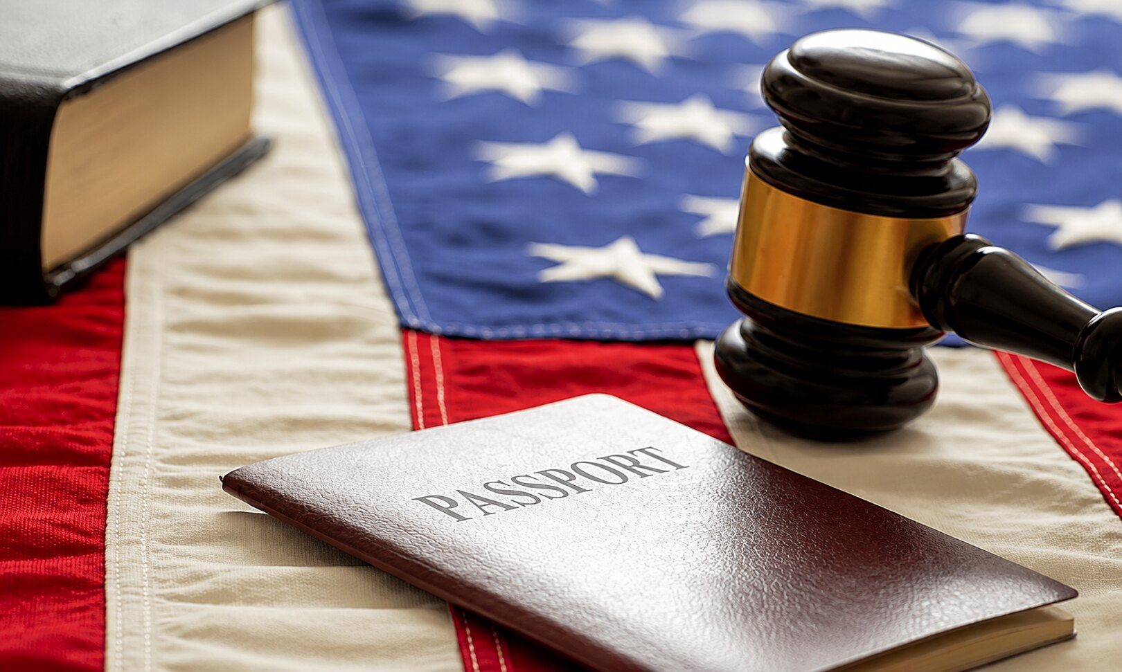 A passport and judge's gavel resting on an American flag