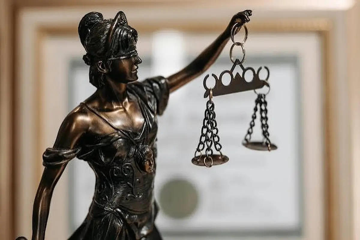 Bronze Lady Justice figure holding balance scales